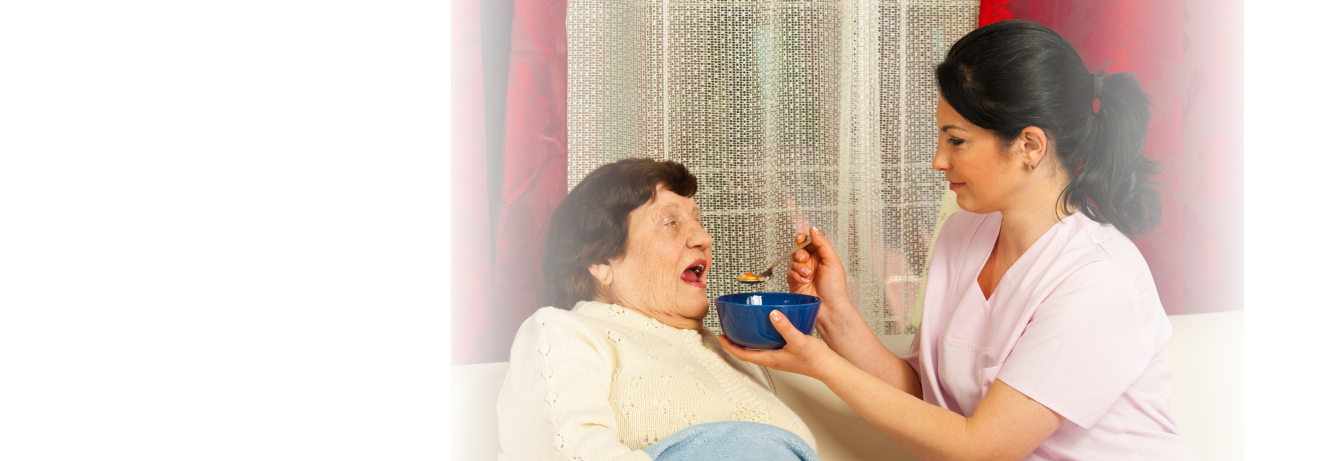 caregiver feeding elderly woman